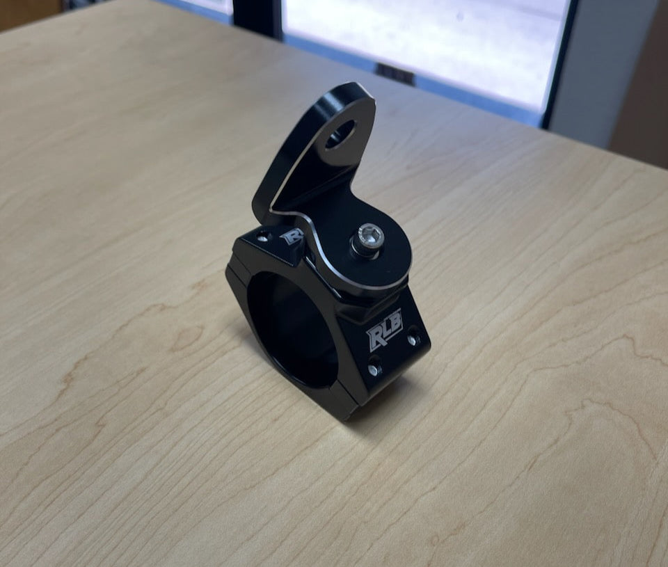 Black metal clamp on a wooden surface with a blurred background