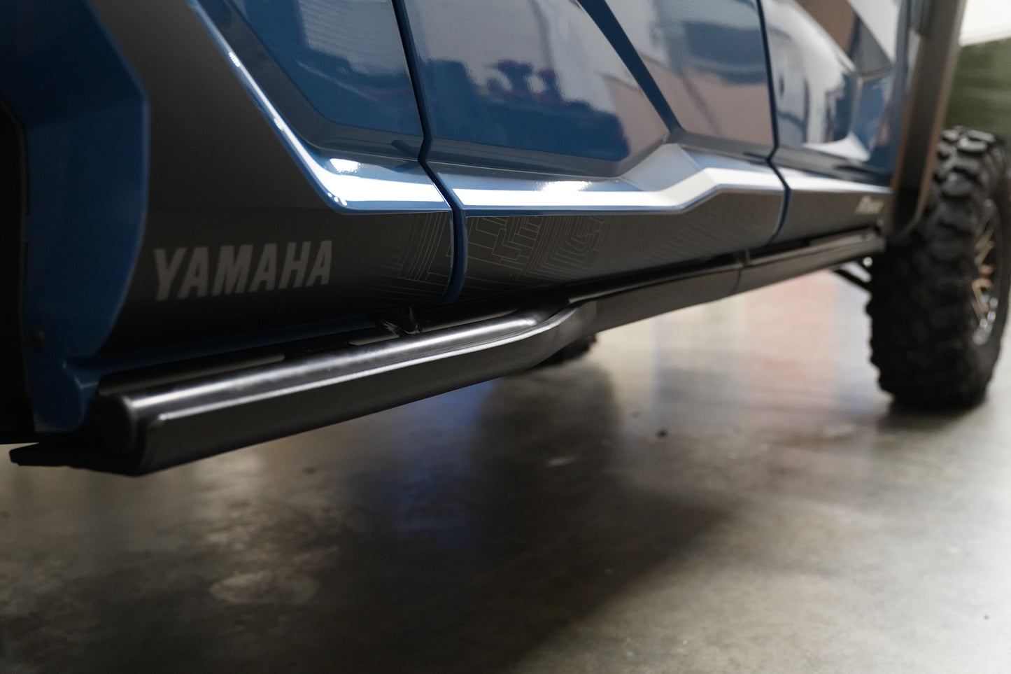 Close-up view of UHMW rock sliders installed on a Yamaha Wolverine RMAX4 for added trail protection.