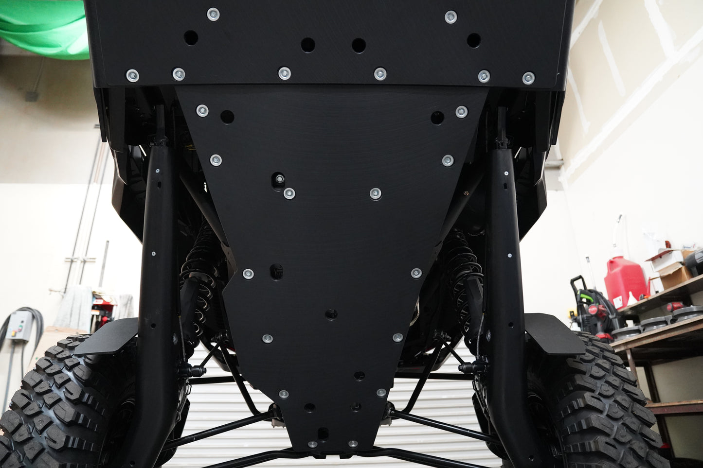 Rear underside view showing Factory UTV UHMW skid plate coverage and trailing arm protection.